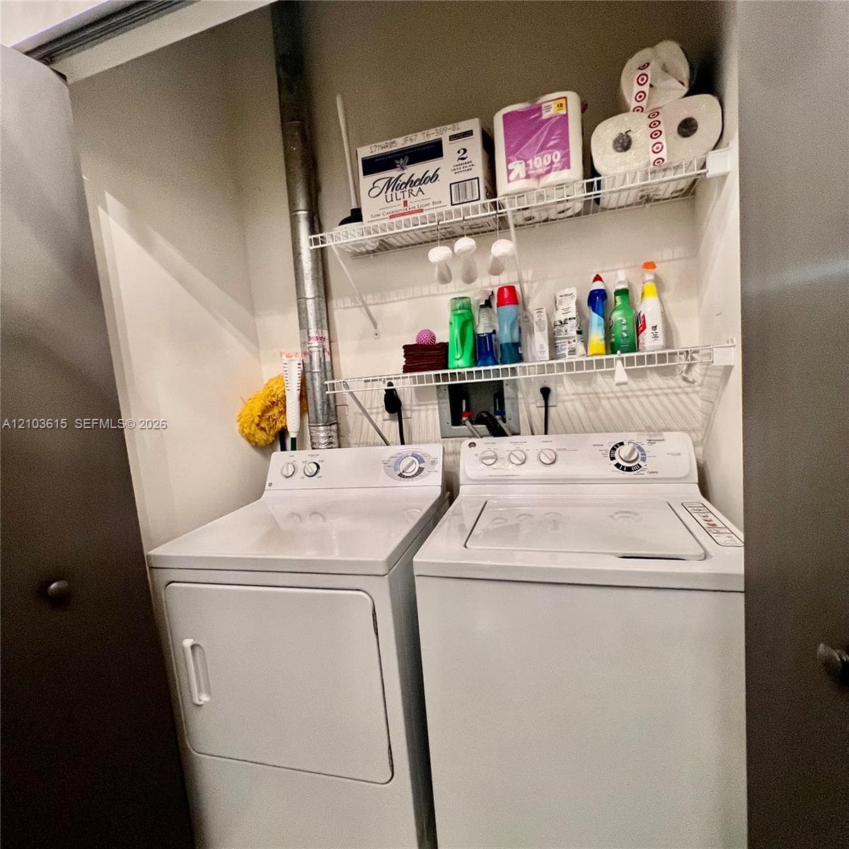 Laundry area featuring dual white top-load appliances and two levels of built-in white wire shelving