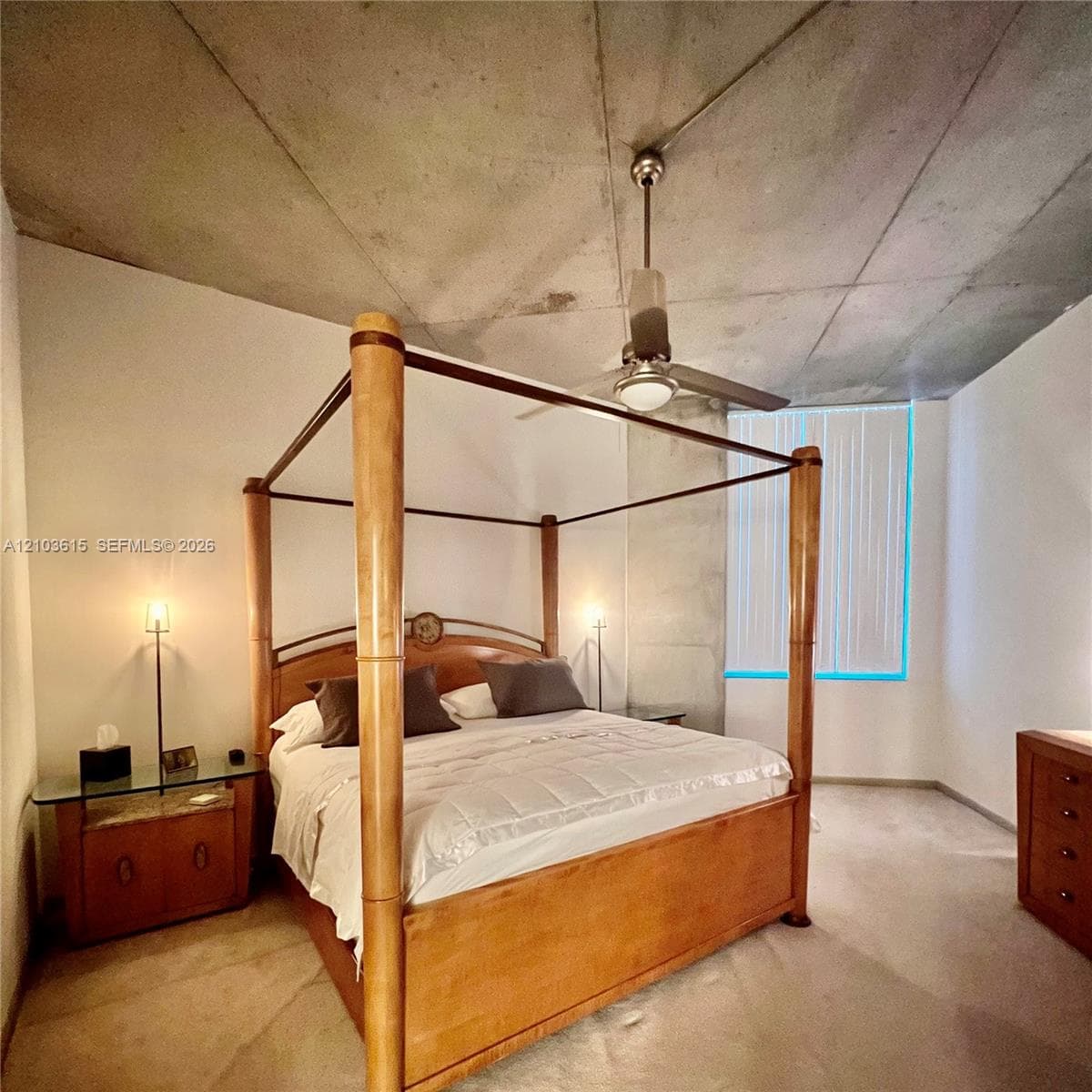 Exposed concrete ceiling, floor-to-ceiling window with vertical blinds, and metal ceiling fan with integrated lighting