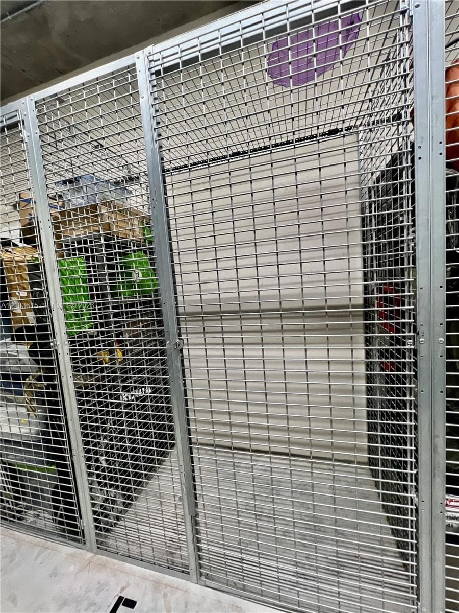 Dedicated storage unit featuring secured wire-mesh partitions, metal framing, and concrete flooring