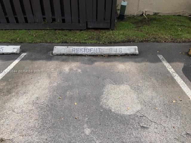 Asphalt paved parking space with designated concrete parking barriers