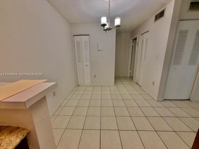 Tile flooring, white walls, and a contemporary chandelier