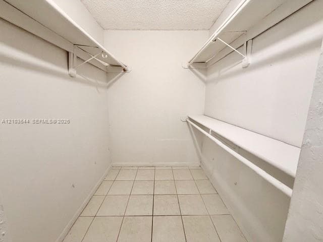 Walk-in closet featuring dual shelving and clothing rods