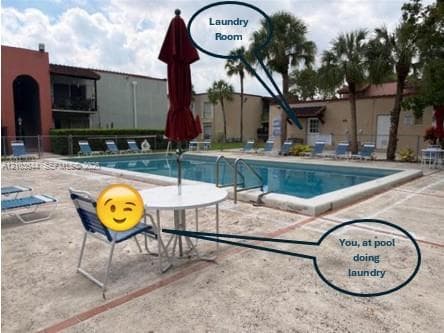 Rectangular in-ground swimming pool with metal handrails and a concrete pool deck