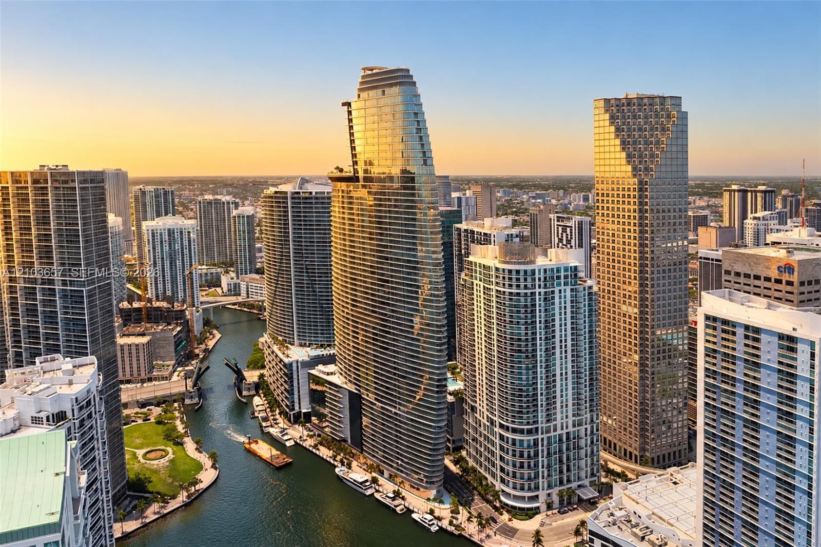High-rise buildings with contemporary glass and concrete exteriors, urban waterway, surrounding cityscape, and distant horizon