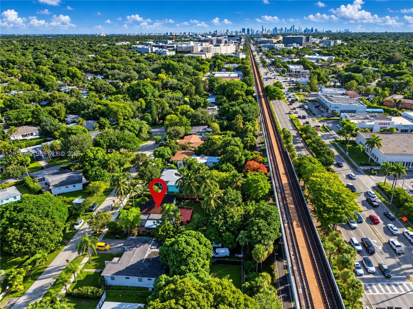 Aerial perspective featuring a residential lot with mature canopy trees, extensive landscaping, and proximity to major thoroughfares and urban skyline