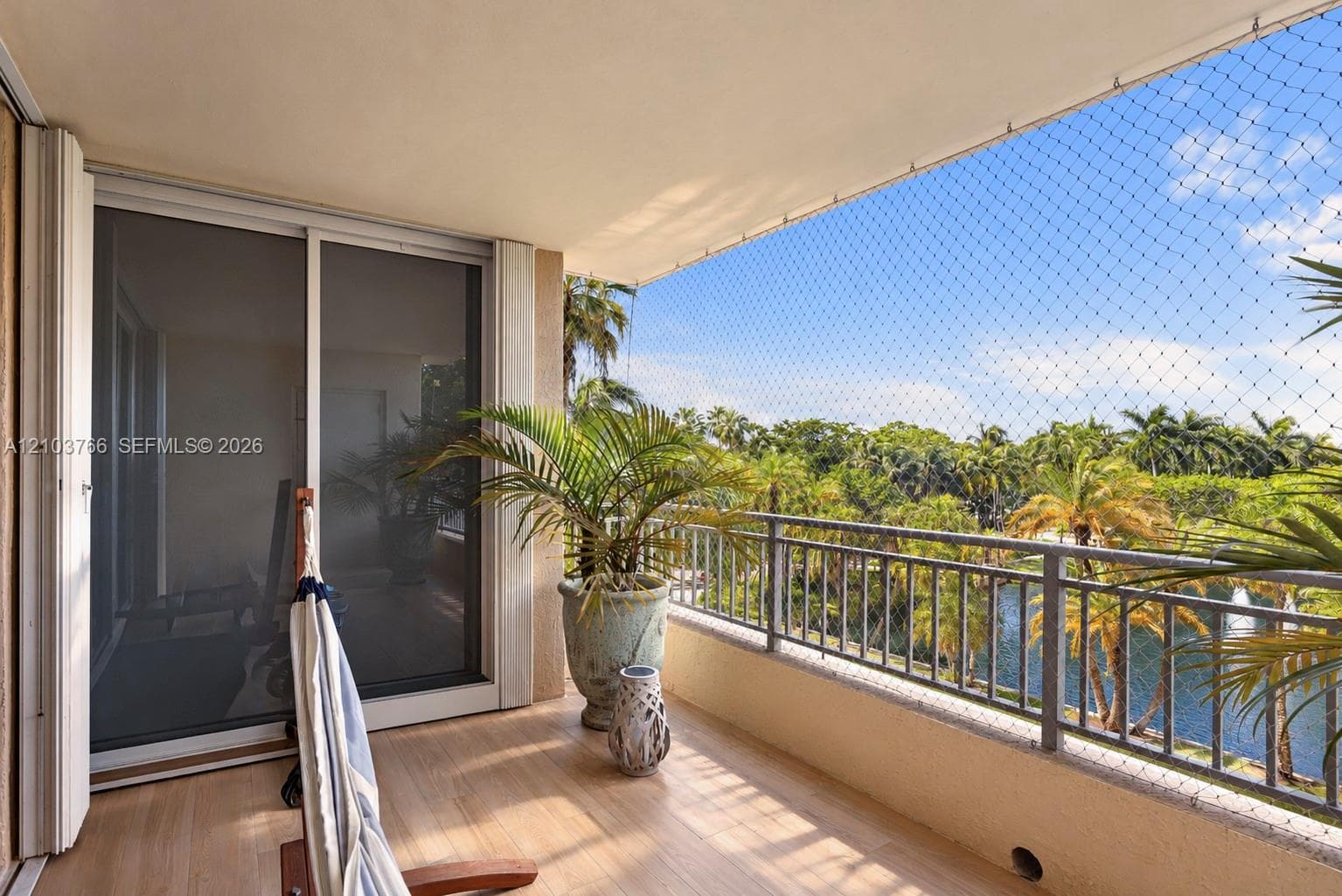 Covered balcony featuring wood-finish flooring, metal railing, and sliding glass entry door