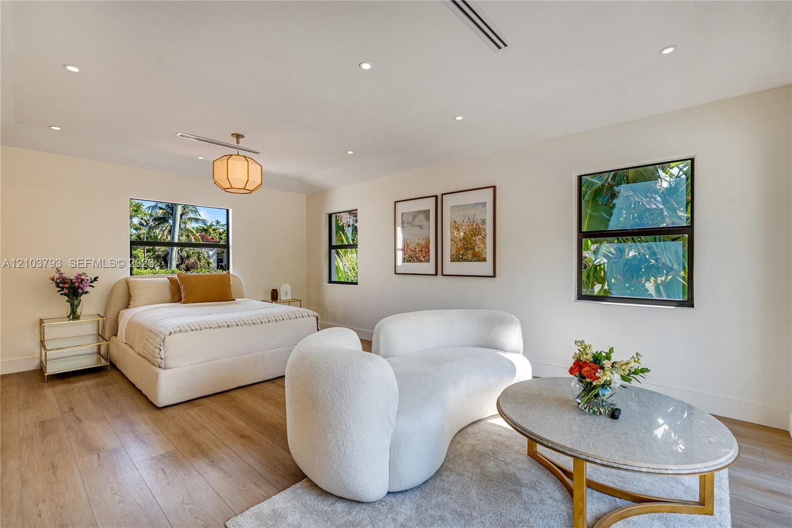 Wood-finish flooring, recessed lighting, geometric pendant fixture, large sliding glass doors, and black-framed windows