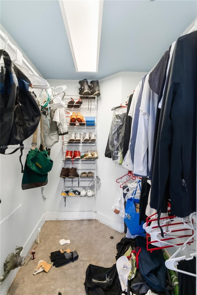 Reach-in storage space featuring built-in dual-level hanging rods and integrated ceiling-mounted lighting