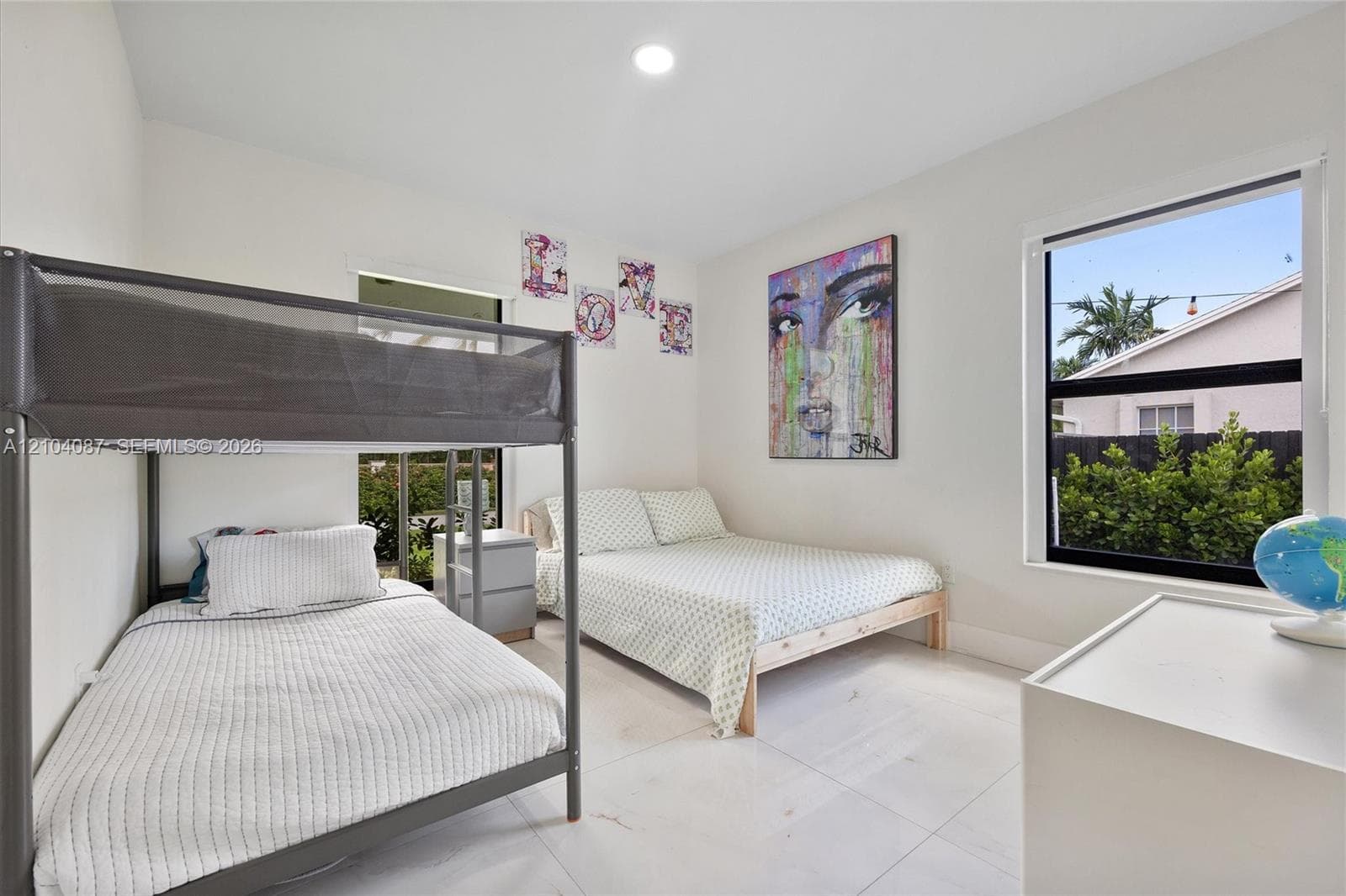 Recessed lighting, large window with exterior landscaping, light tile flooring, white walls, and a built-in window