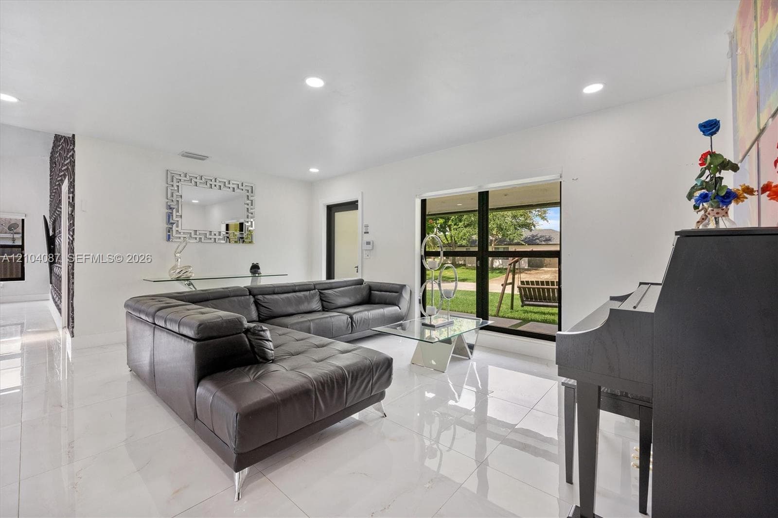Recessed lighting illuminates the bright interior with large format tile flooring