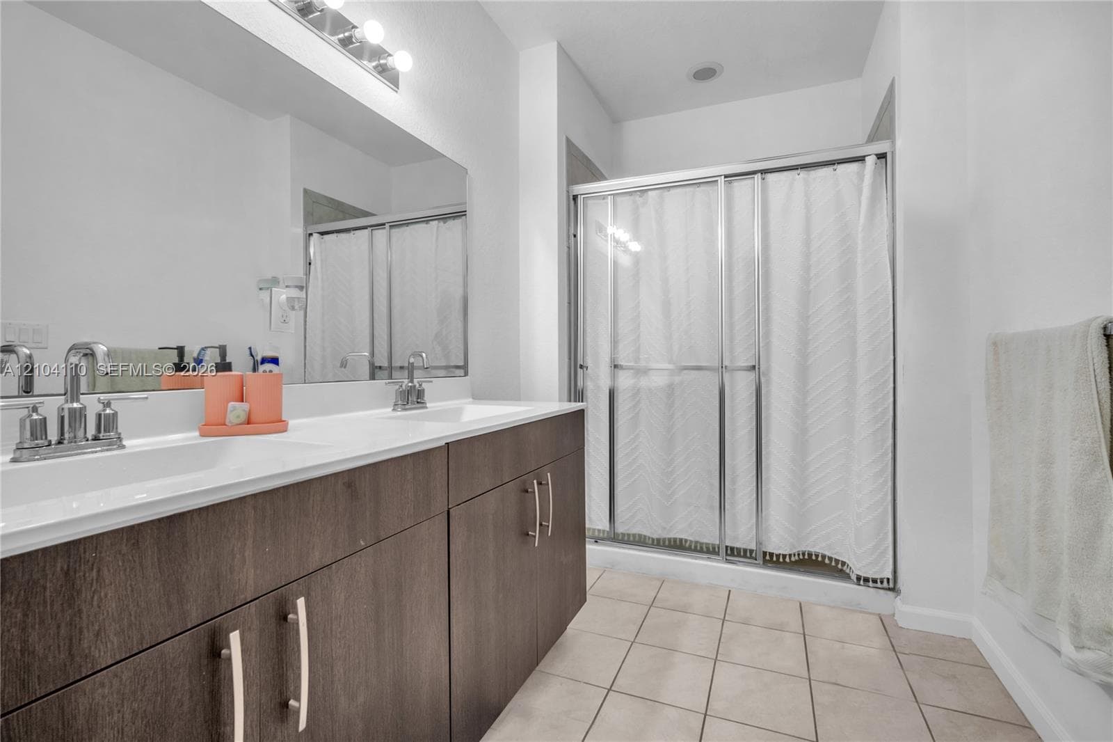 Dual vanity with chrome fixtures and dark wood-finish cabinetry