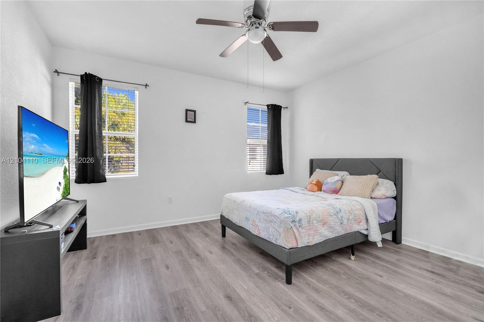 Recessed lighting, wood-finish flooring, ceiling fan, and two windows with blinds