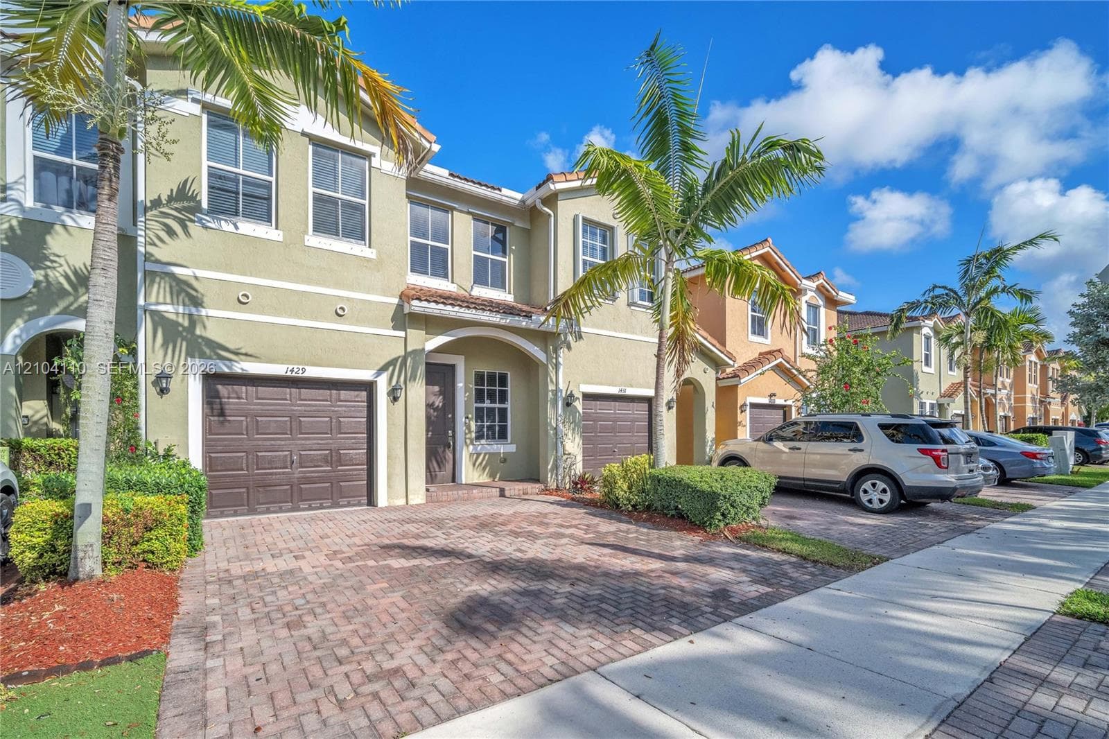Stucco exterior with decorative window shutters and arched entryways
