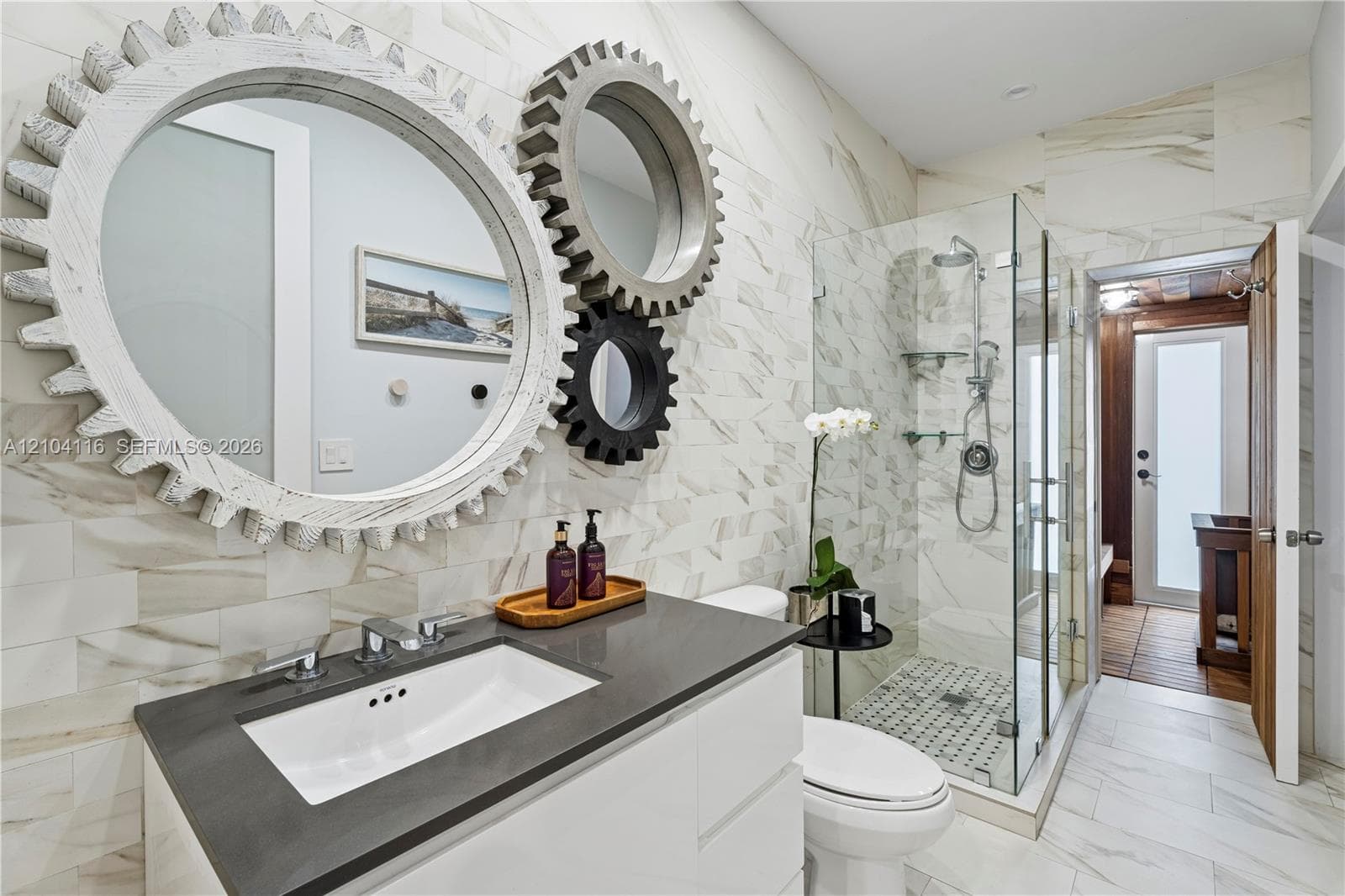 Modern bathroom featuring a single vanity with a white rectangular undermount sink, dark countertop, and chrome faucet