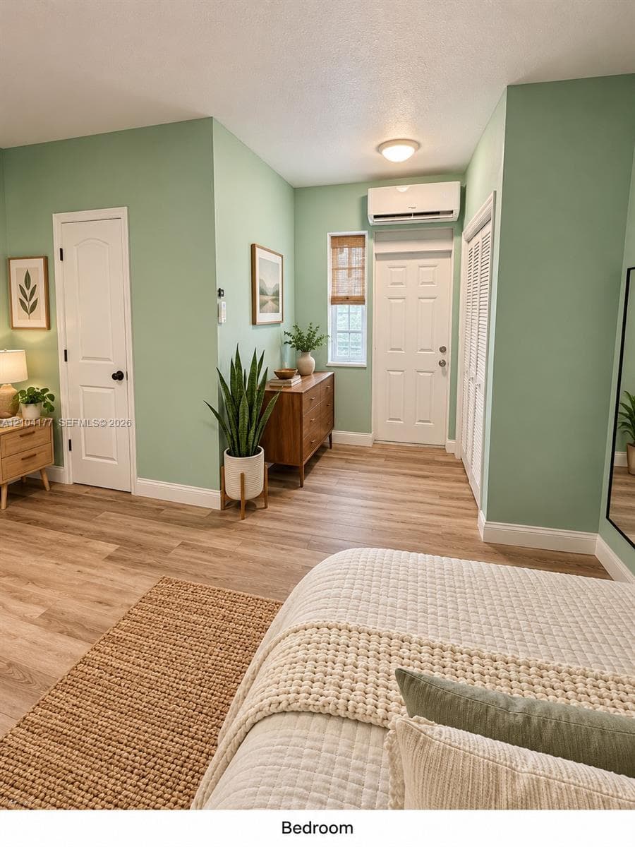 Wood-finish flooring, wall-mounted ductless climate control unit, multi-panel doors, and bifold closet doors
