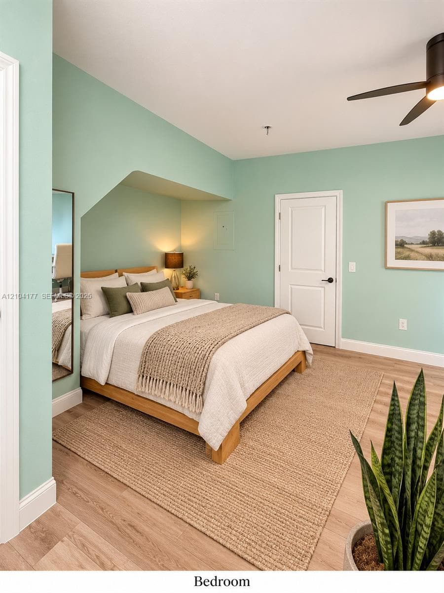 Architectural recessed alcove, wood-finish flooring, and matte black ceiling fan with integrated lighting