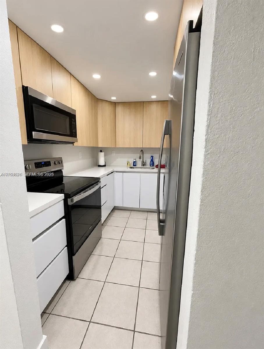 Modern bathroom featuring a wood-finish floating vanity, walk-in shower with floor-to-ceiling tile, rectangular integrated sink, and mirrored medicine cabinet