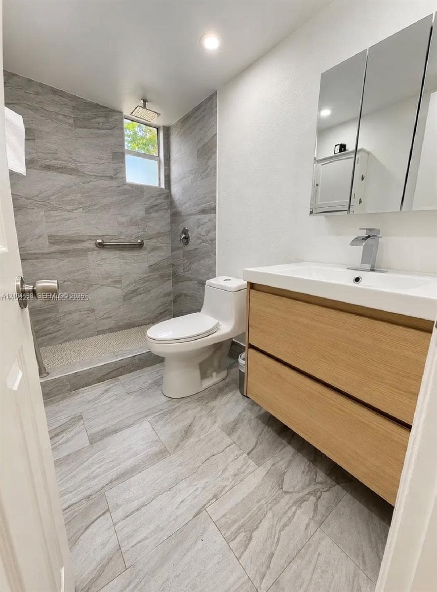Neutral-toned ceramic tile flooring, textured ceiling, and a large horizontal window with metal frame