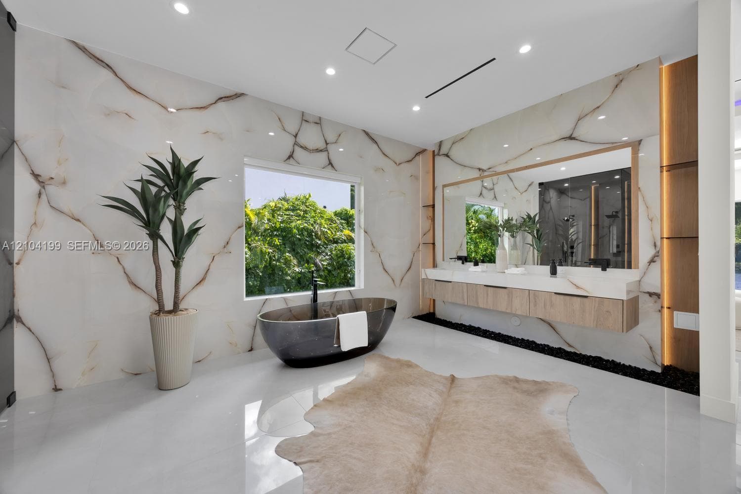 Custom storage system featuring floor-to-ceiling cabinetry with glass-panel doors, integrated LED lighting, central built-in island with storage drawers, wood-finish cabinetry, and high-gloss flooring