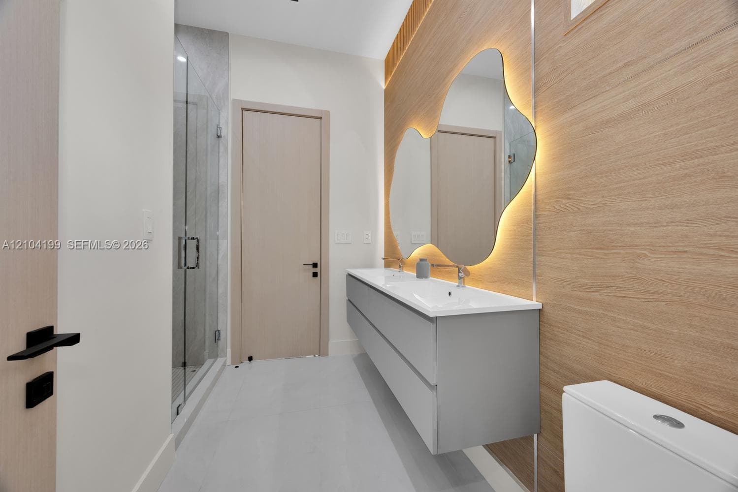 Neutral-toned room featuring smooth concrete-finish flooring, recessed lighting, light-wood interior doors, and a sliding barn-style door