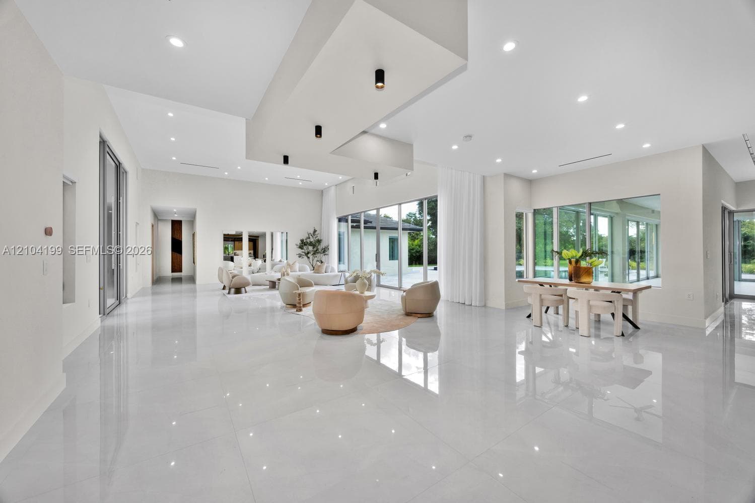 Tray ceiling featuring recessed accent lighting, large-format tile flooring, and sliding glass doors