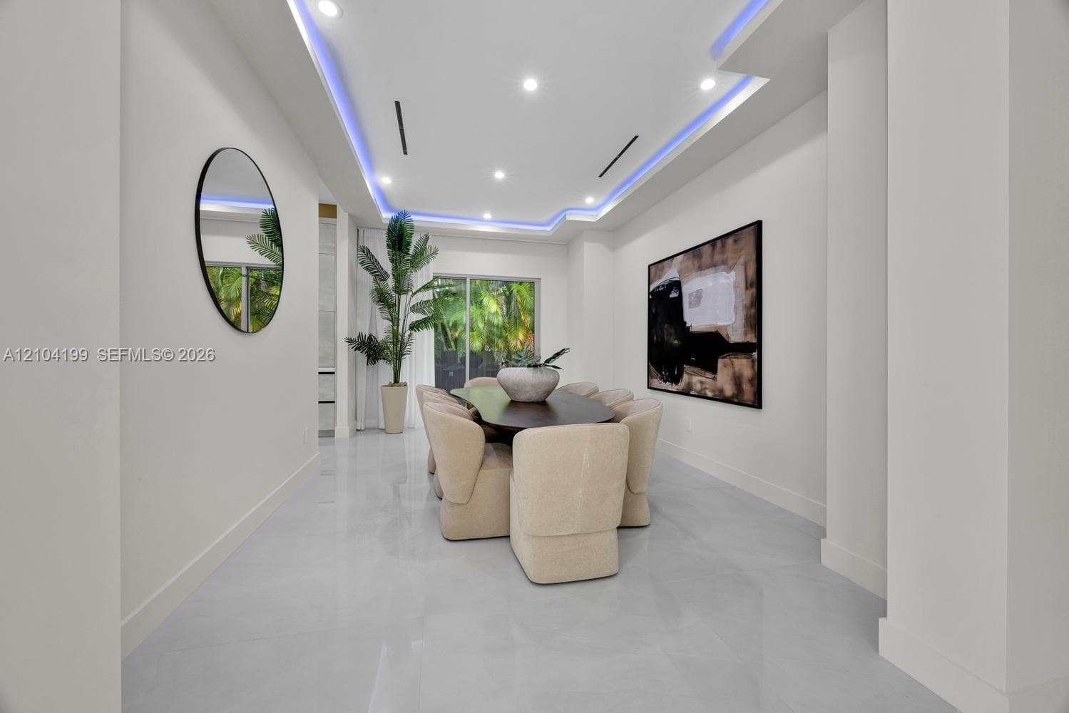 Open-concept interior featuring large-format tile flooring, recessed lighting, and a kitchen equipped with a central island and contemporary flat-panel cabinetry