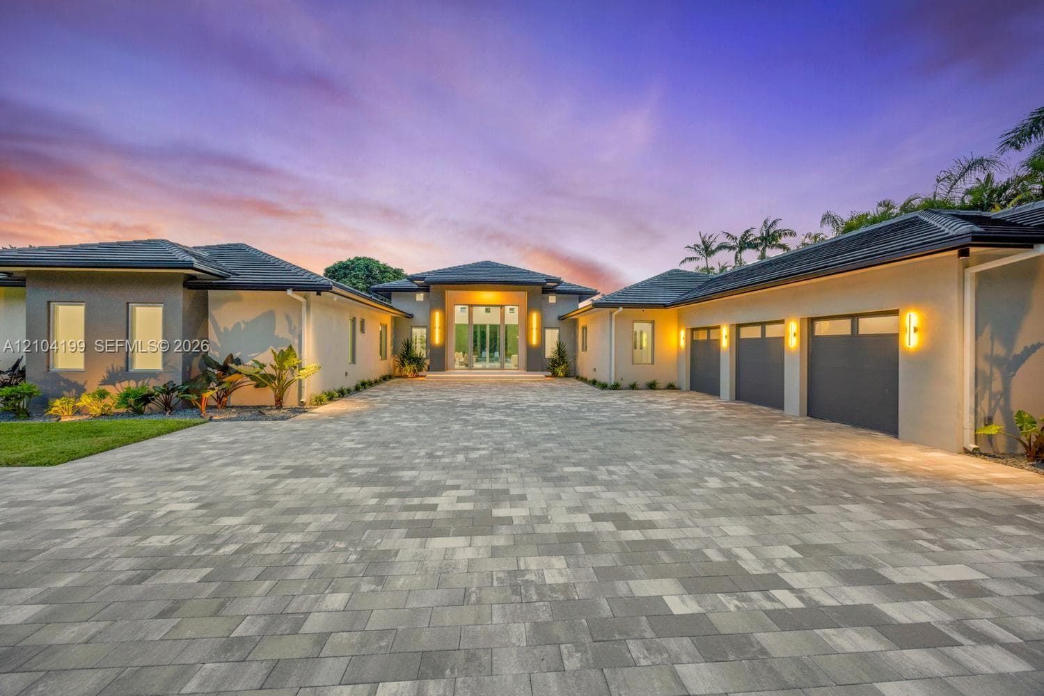 Expansive stone patio featuring an in-ground pool, integrated spa, and floor-to-ceiling glass wall panels