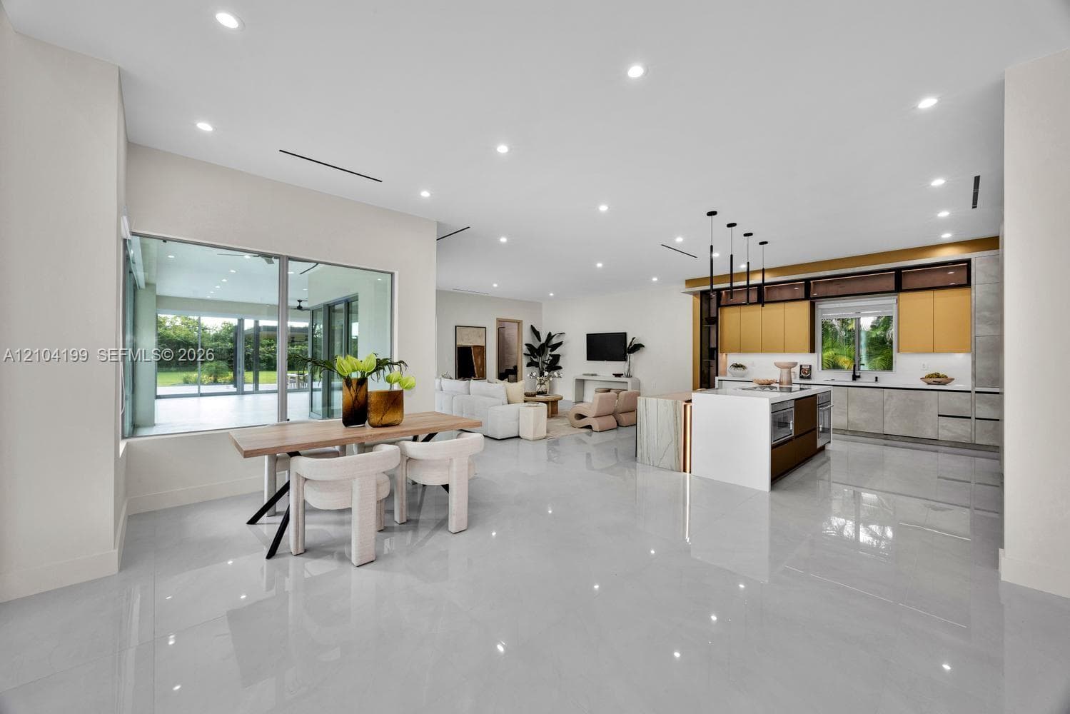 Custom kitchen featuring a stone-topped waterfall island, full-height cabinetry with integrated refrigeration, metallic-tone upper accent cabinets, and recessed ceiling lighting