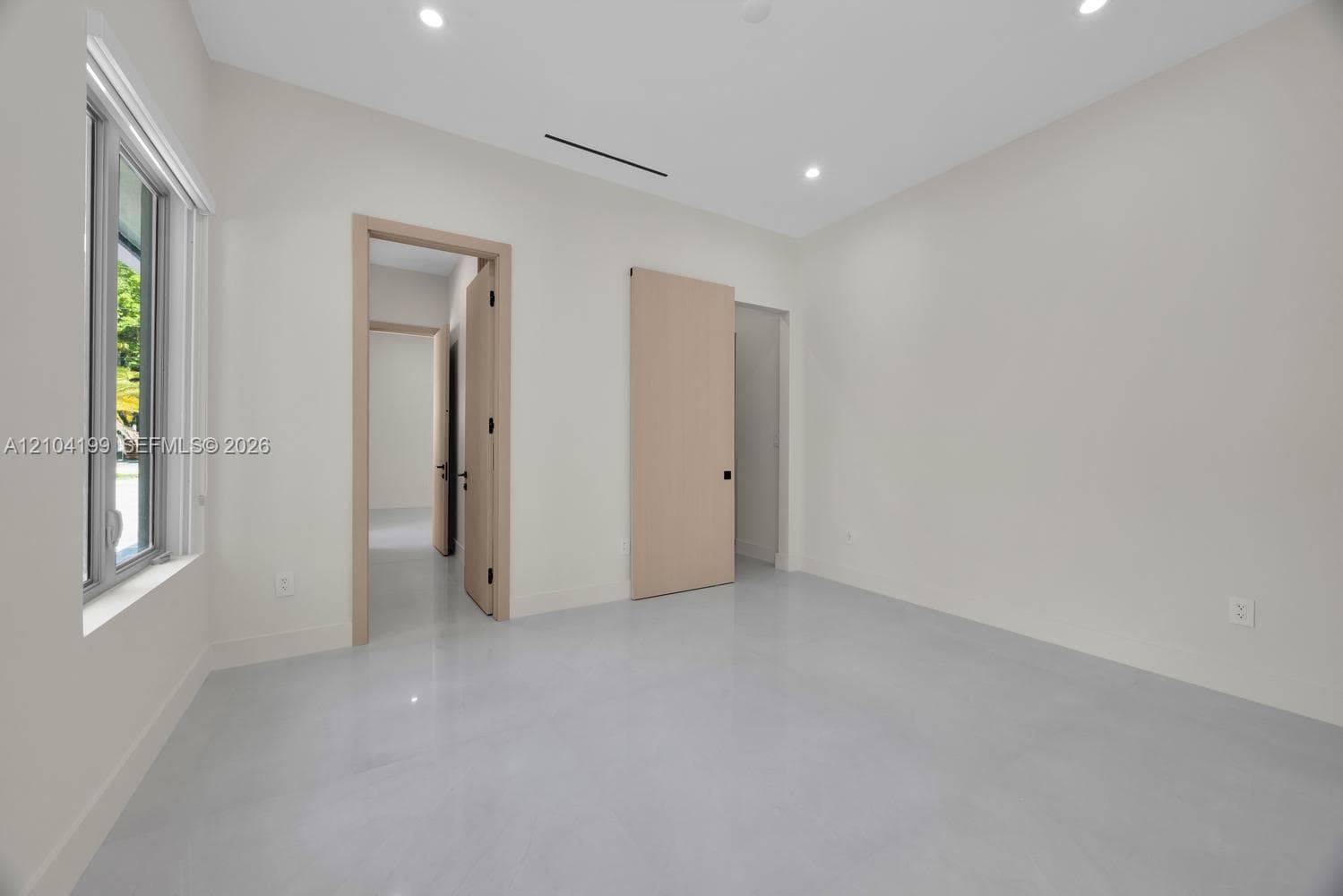 Polished tile flooring, floor-to-ceiling sliding glass-panel closet doors, and dual casement windows with integrated shades