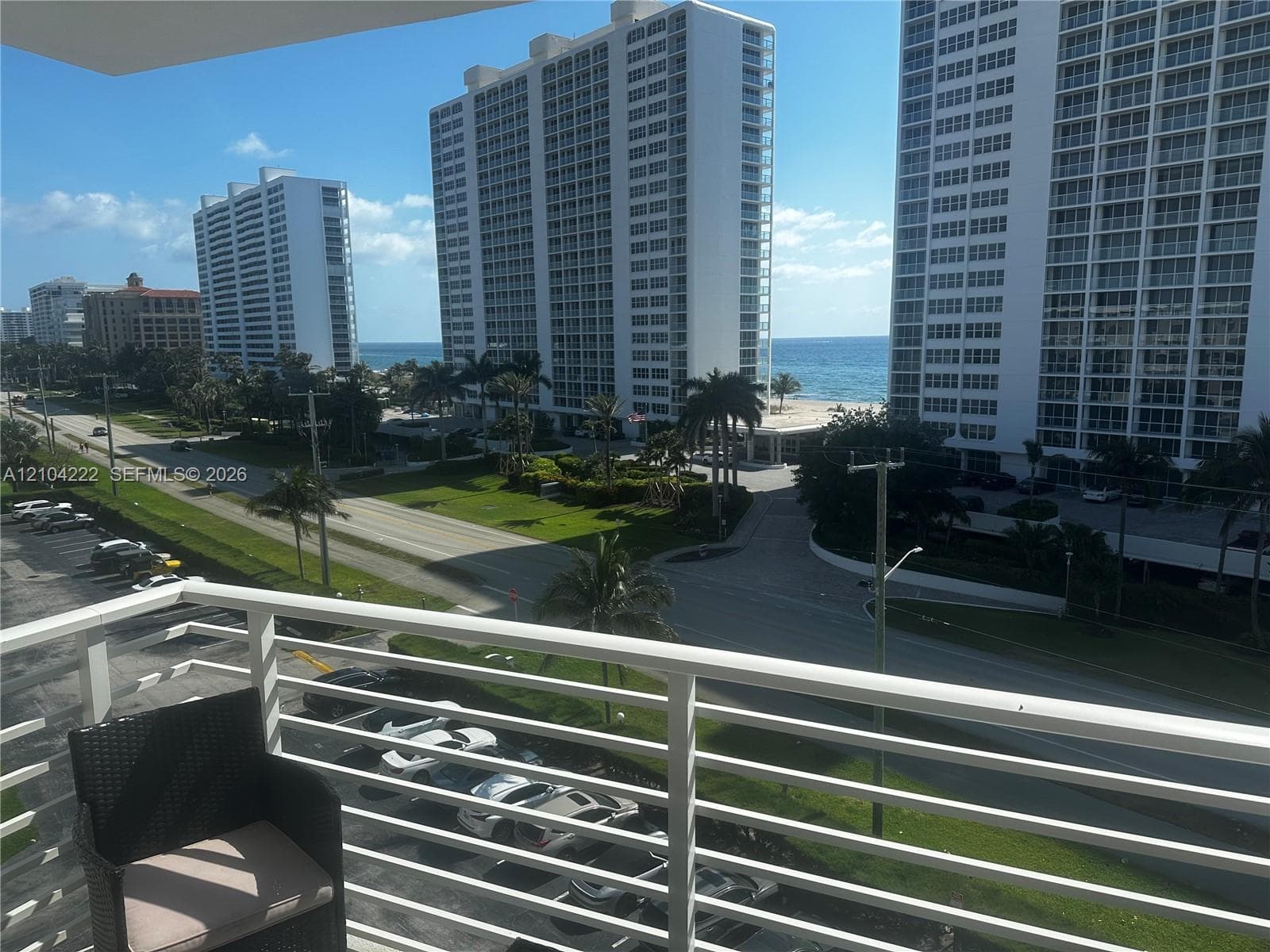 Private balcony featuring a white metal railing and ocean horizon backdrop