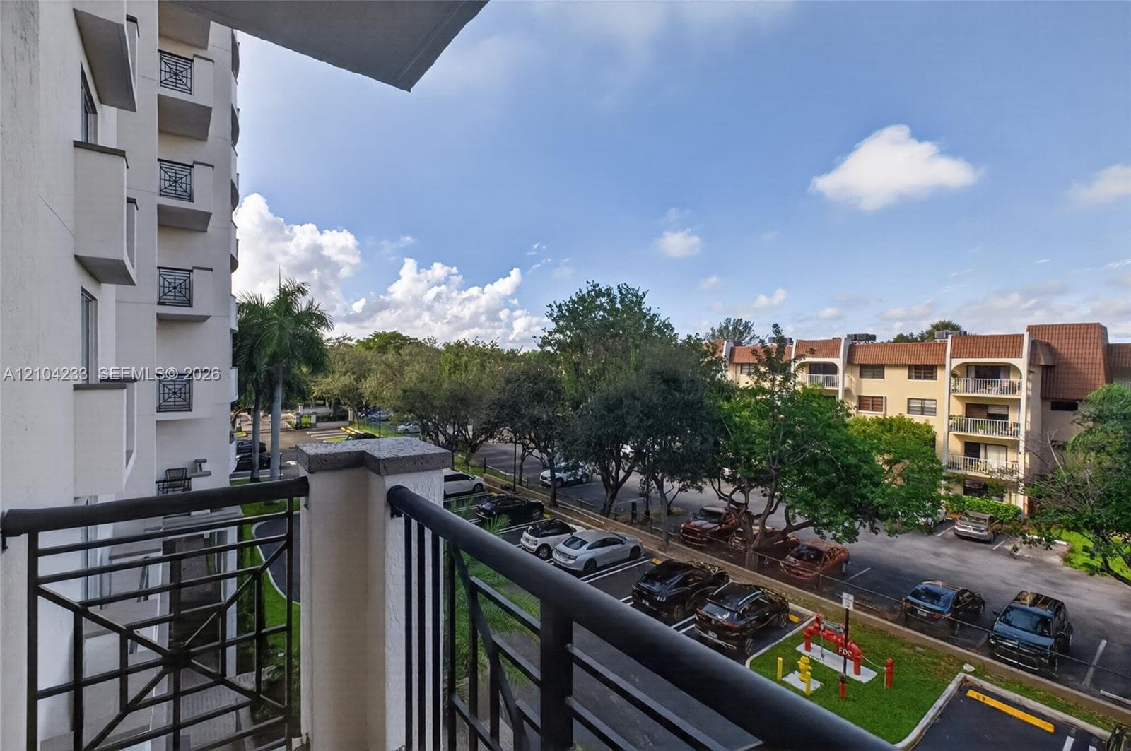 Private balcony with metal railings, featuring stone-capped masonry pillars and decorative lattice-work panels