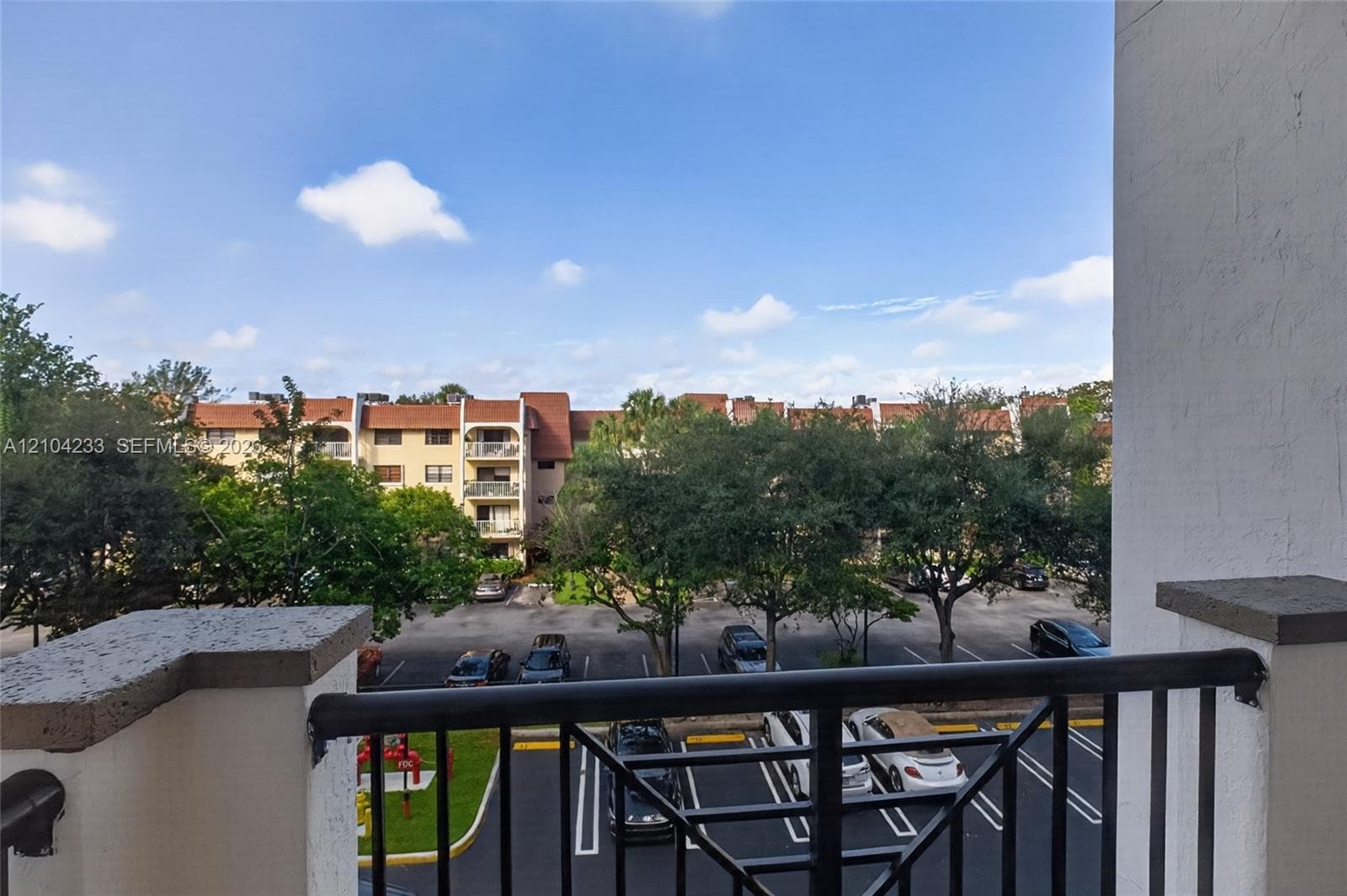 Balcony featuring black metal railings and stucco pillars