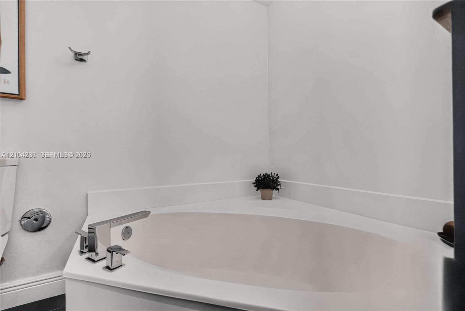 Corner soaking tub with integrated backsplash and polished chrome deck-mounted faucet