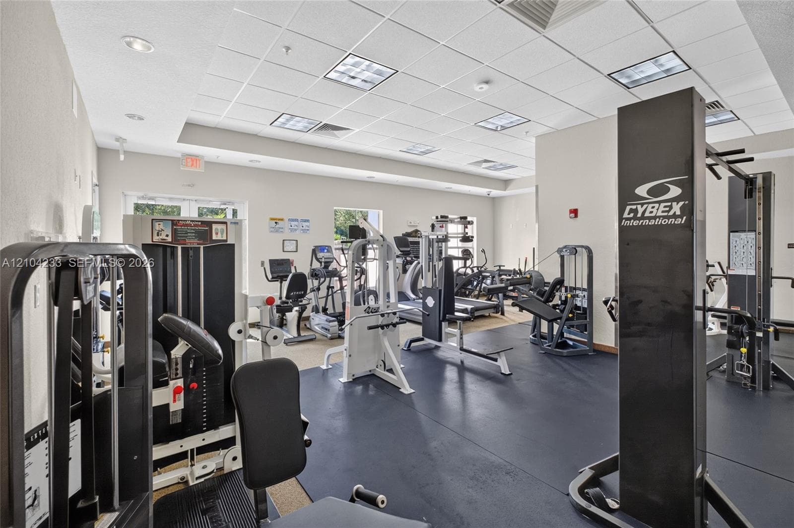 Fitness center featuring professional-grade exercise equipment, rubberized flooring, and recessed ceiling lighting
