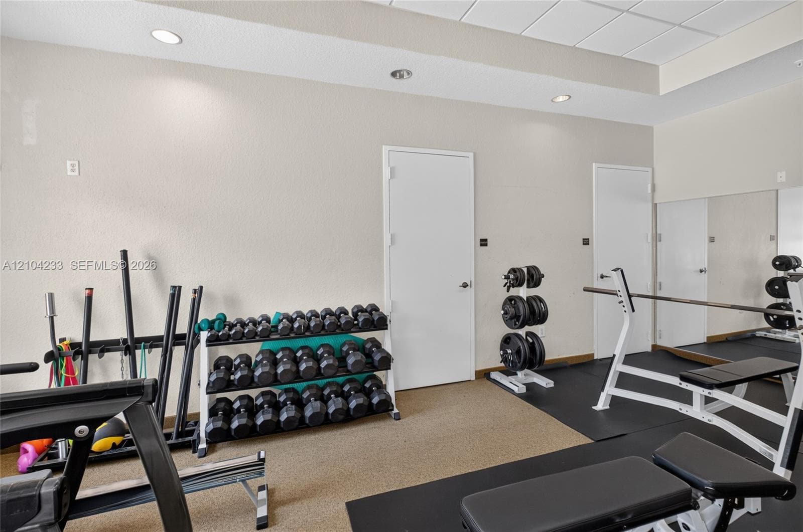 Fitness room featuring recessed lighting, a full-length wall mirror, and integrated rubberized flooring
