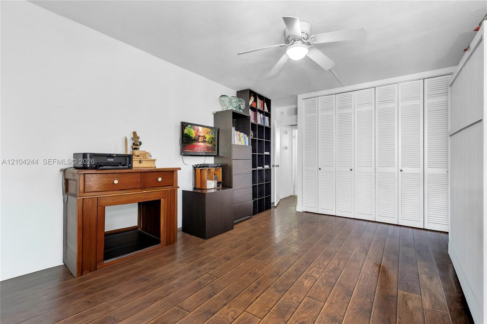 Bedroom with it's own bathroom. Floor-to-ceiling white louvered closet doors