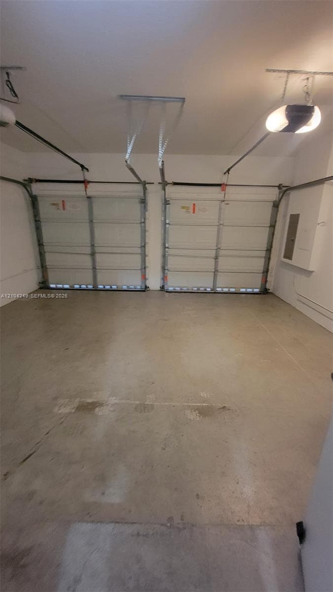 Two-car garage featuring dual overhead doors, concrete flooring, and ceiling-mounted automatic door openers