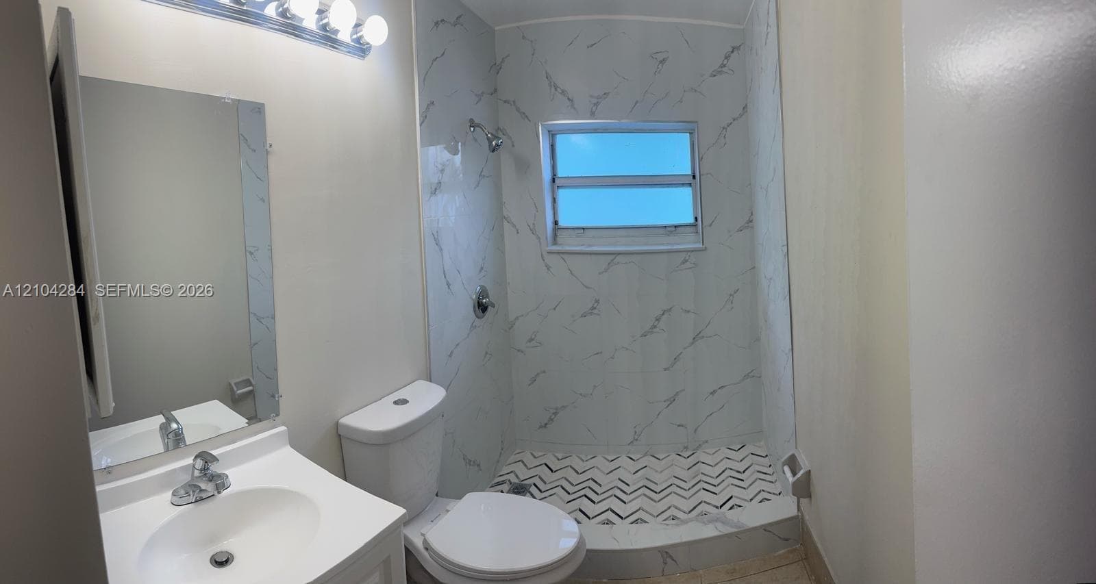 Covered patio featuring patterned tile flooring, built-in outdoor cabinetry with a countertop, integrated double wall oven, and wall-mounted exterior lighting