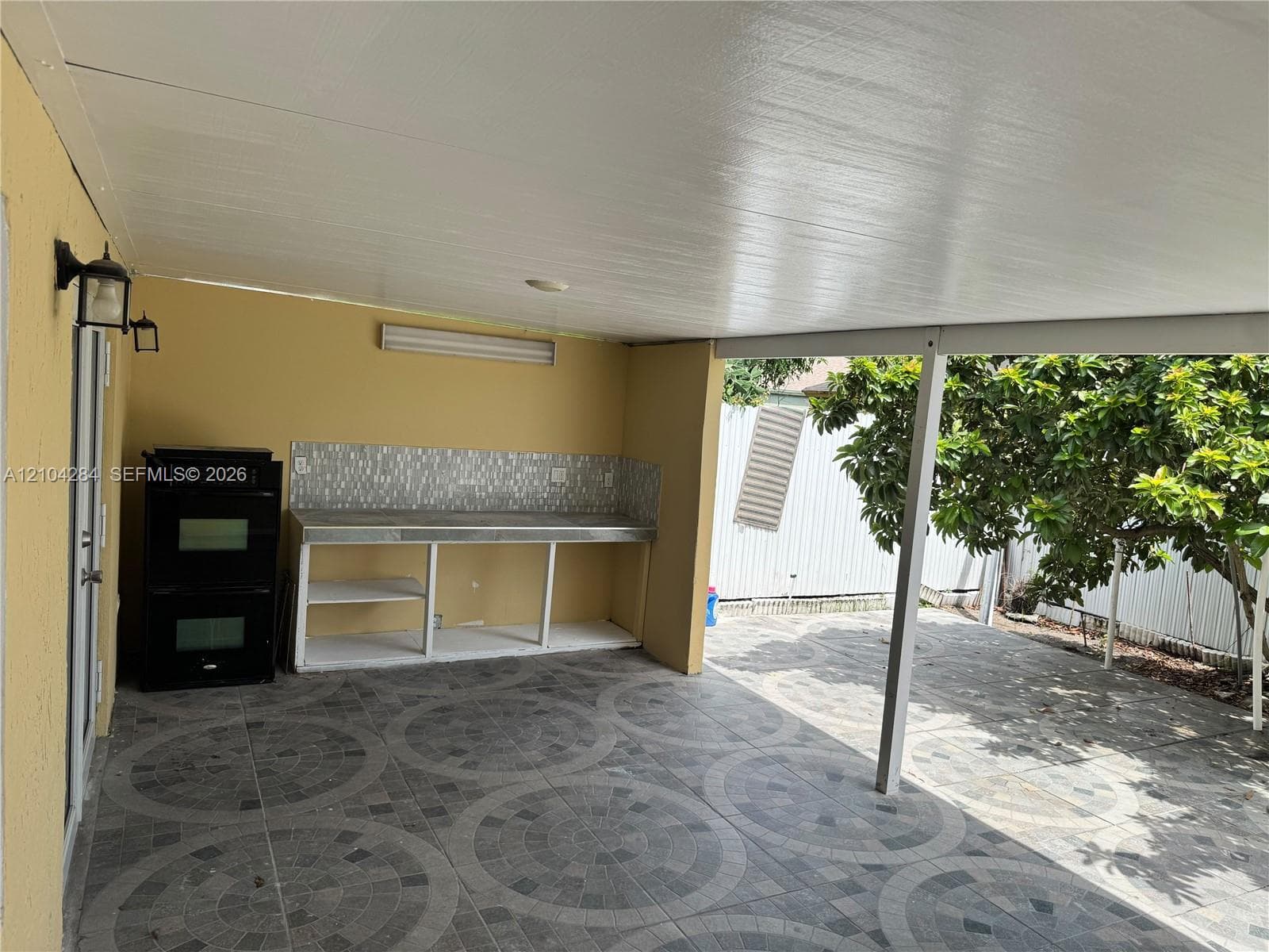 Single-car garage featuring painted textured walls, epoxy-coated flooring, ceiling-mounted lighting, and integrated laundry utility hookups