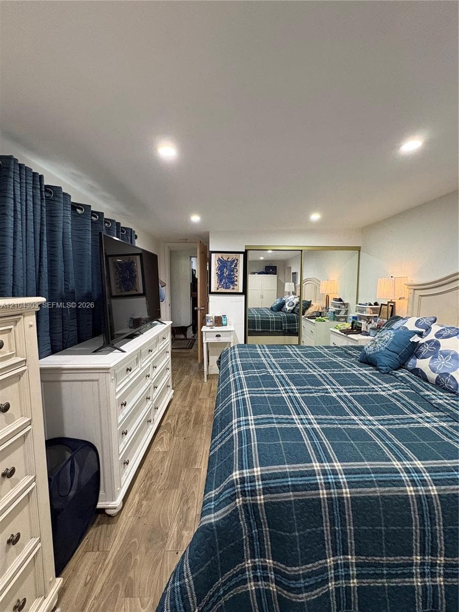 Interior space featuring recessed lighting, wood-finish flooring, and a mirrored closet with sliding doors