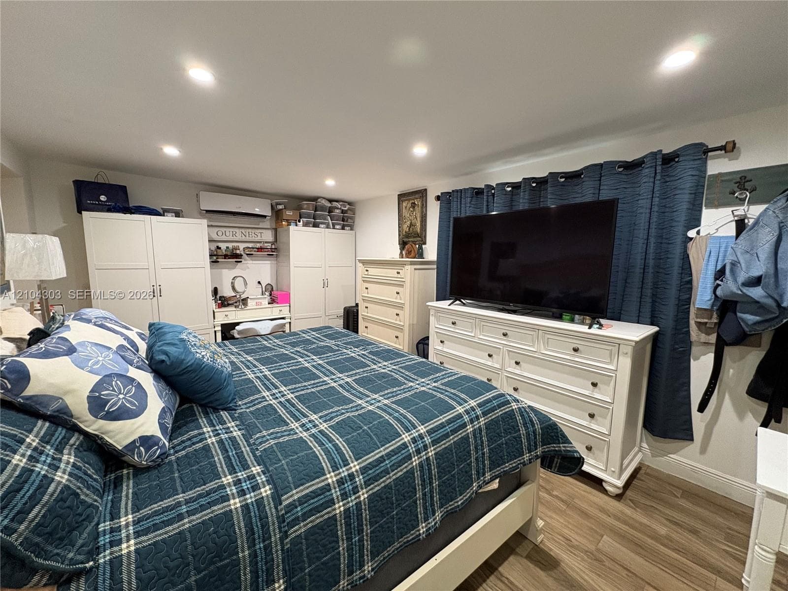 Recessed ceiling lighting, wood-finish flooring, and wall-mounted climate control unit