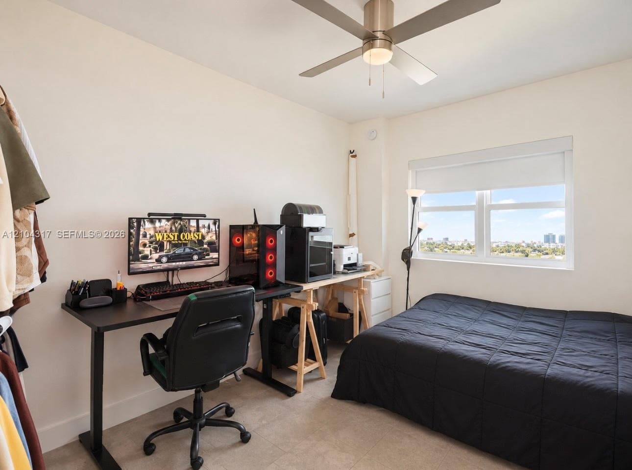 Neutral-toned walls, ceiling fan with integrated lighting, large window with roller shade, and solid-surface flooring