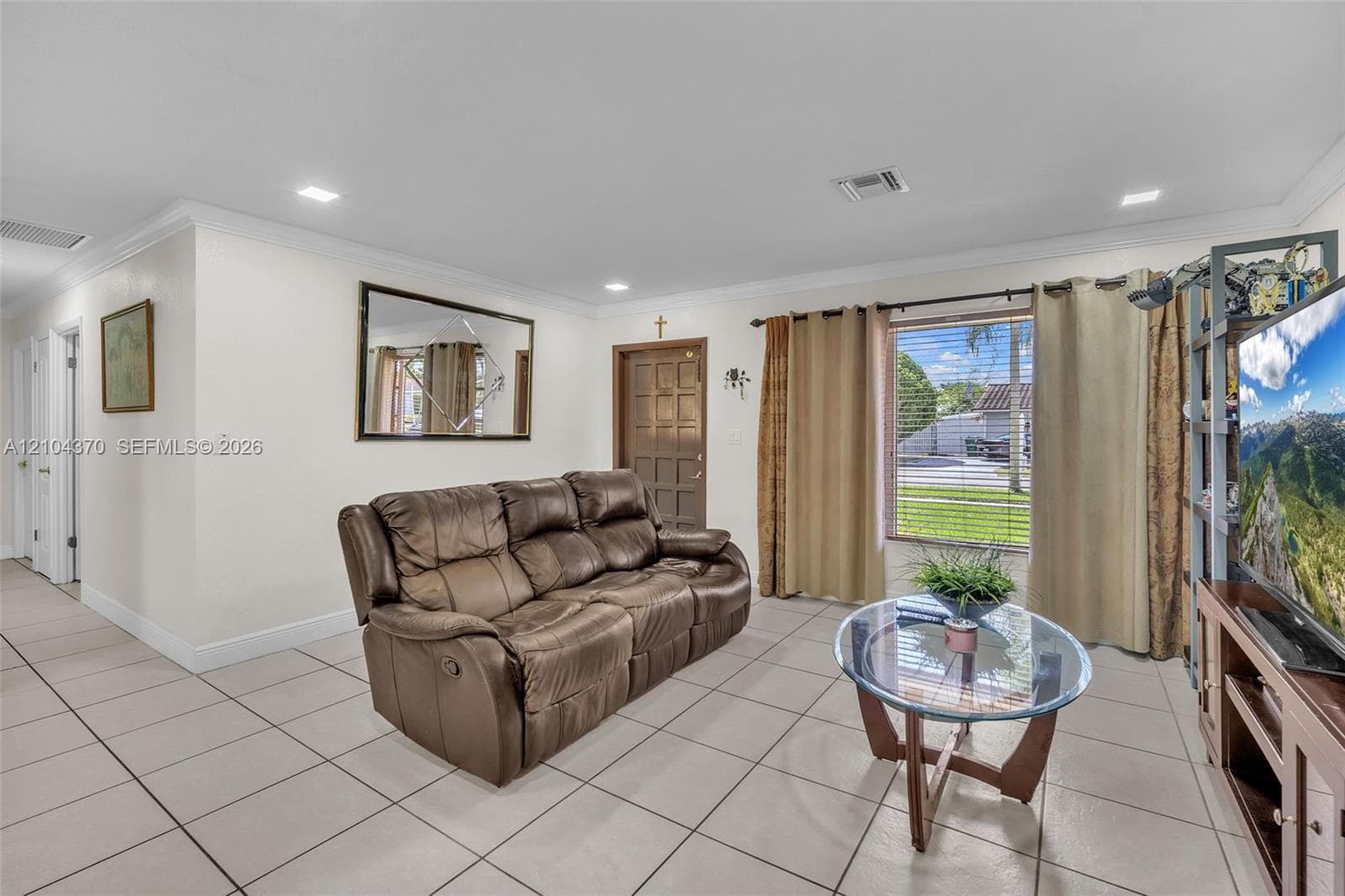 Single-story residence featuring a stamped concrete driveway, one-car garage, manicured lawn, and mature landscaping