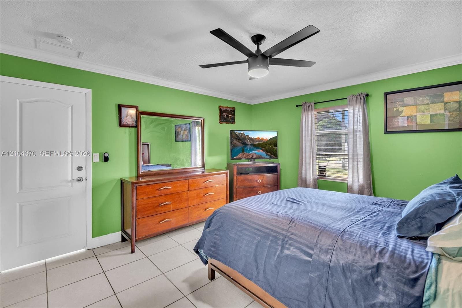 Room featuring tile flooring, crown molding, and a ceiling fan with integrated lighting