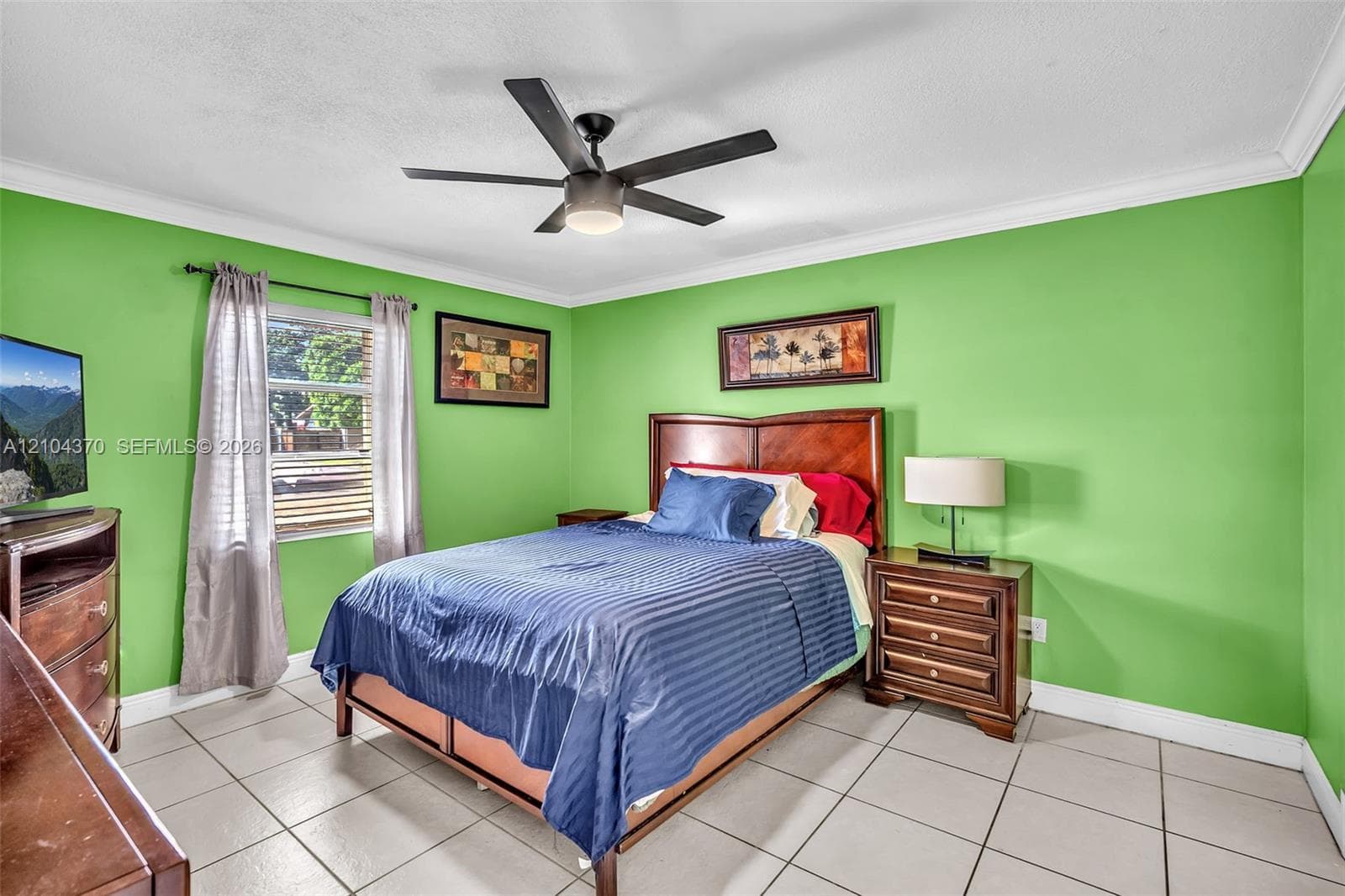Interior space featuring ceramic tile flooring, a white ceiling fan with integrated lighting, crown molding, and a single-panel interior door
