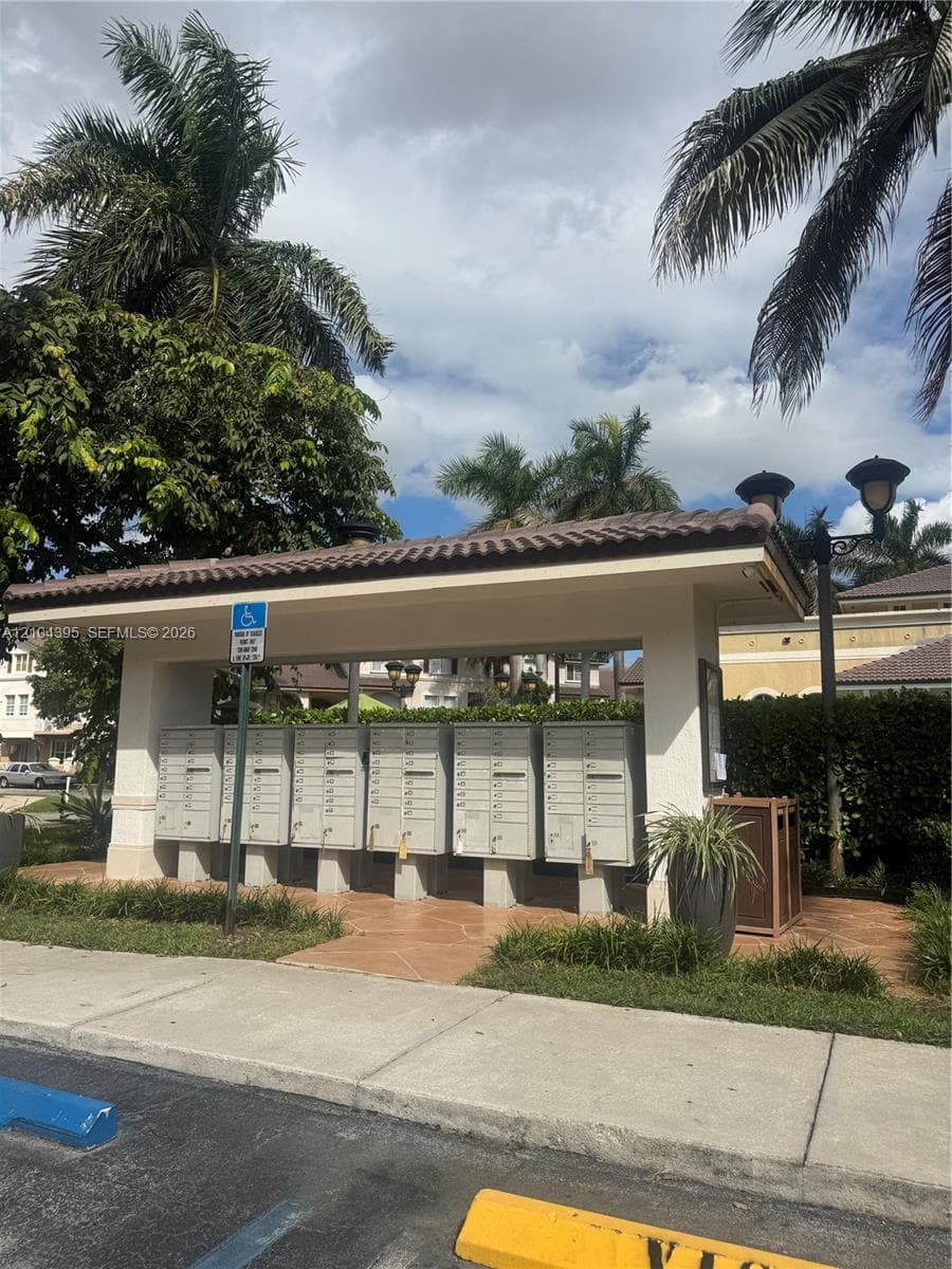 Covered mail kiosk featuring multiple locking compartments, a tiled roof, and integrated pillar lighting