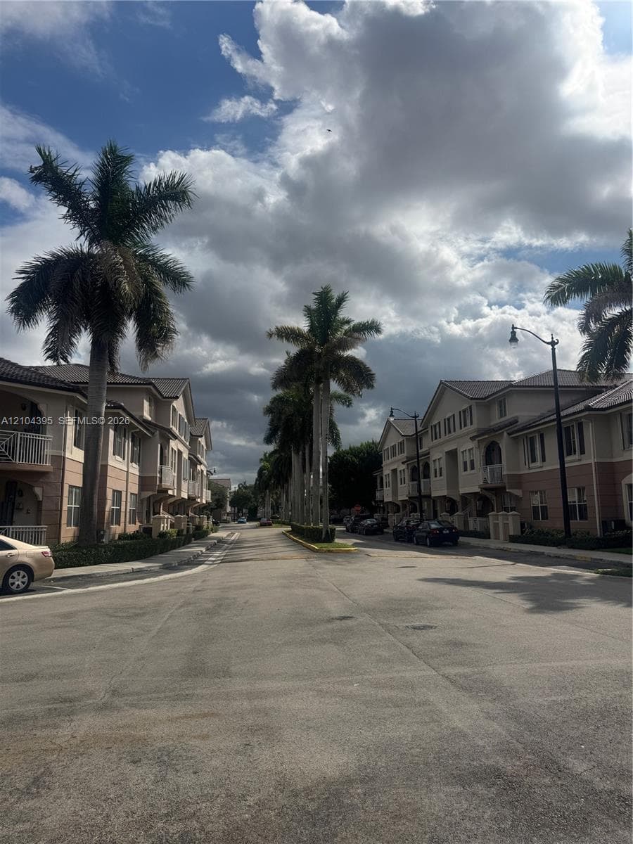 Multi-story residential exteriors featuring stucco facades, multi-pitched tile roofing, private railed balconies, and mature palm tree landscaping