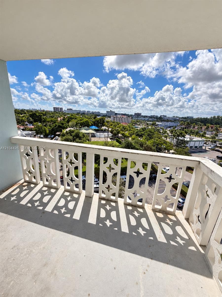 Covered balcony featuring decorative lattice-work concrete railing and expansive outdoor space