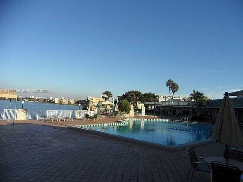 In-ground swimming pool with stone paver decking and perimeter metal fencing