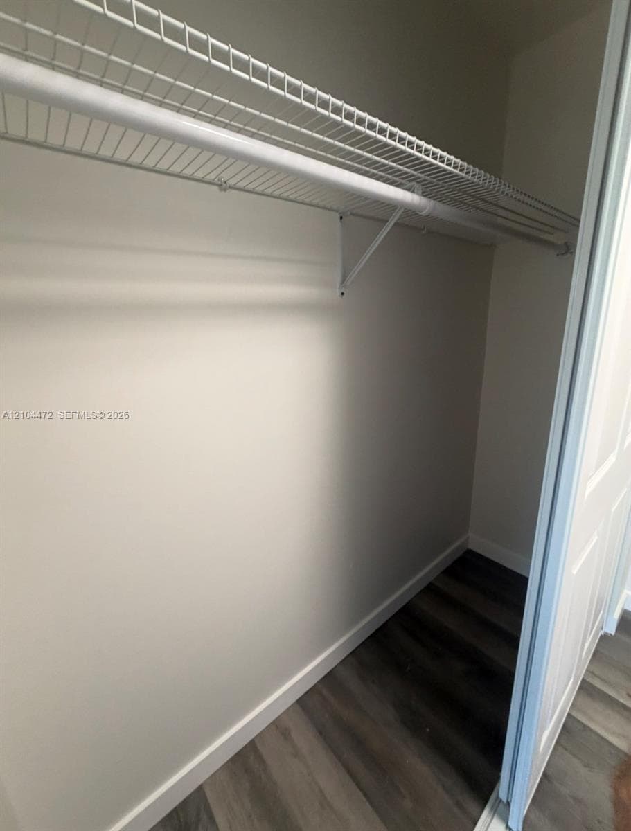Storage space featuring wood-finish flooring and wire shelving